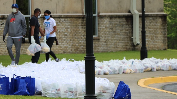 volunteers line up bags of groceries
